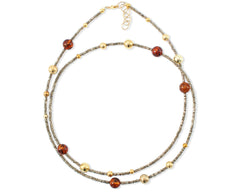 Langes Collier mit Hämatit, vergoldeten Kugeln und Bernstein in Cognacfarbe
